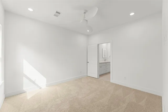 an empty room with an entryway and kitchen