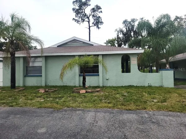 a house with green field in front of it
