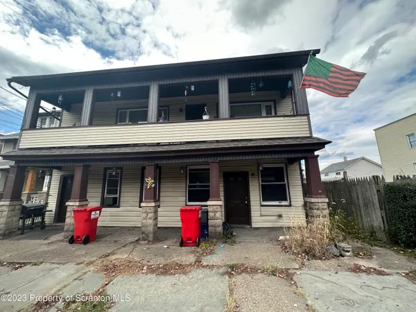 a view of a house with a patio and a yard