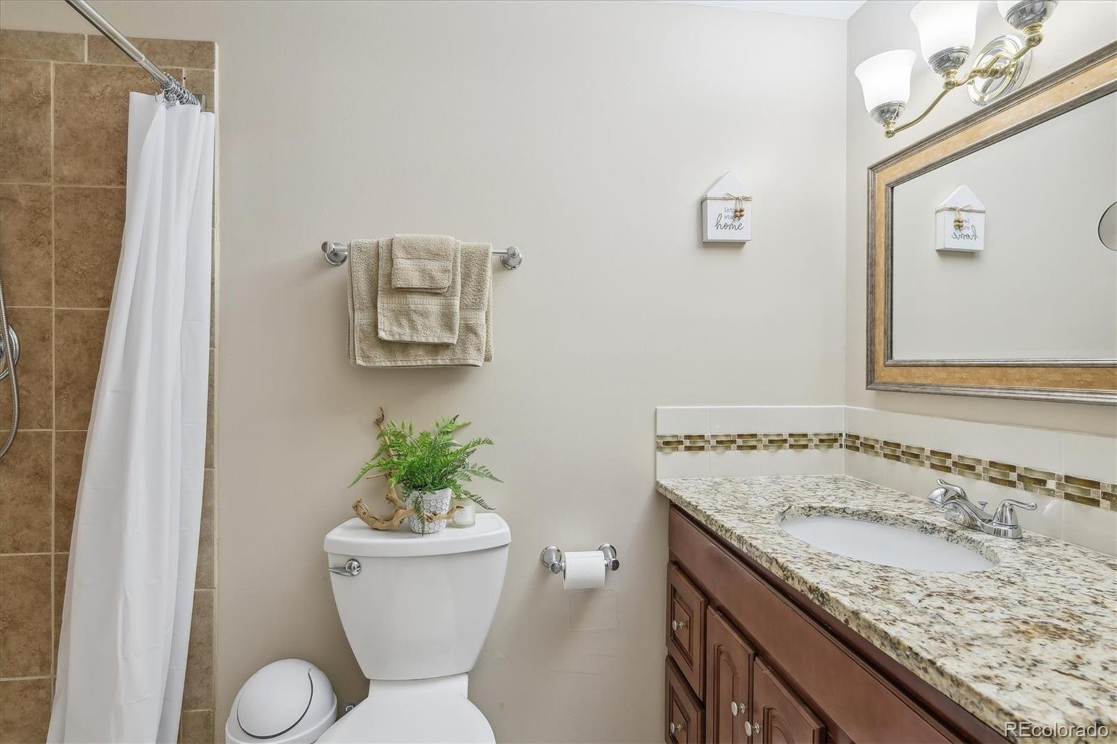 9655 Center Avenue, Unit 5A Denver, CO 80247 - Photo 13 of 45 a bathroom with a granite countertop sink and a mirror