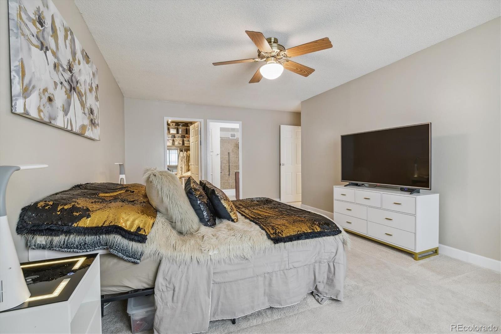 9655 Center Avenue, Unit 5A Denver, CO 80247 - Photo 14 of 45 a bedroom with a bed and a flat screen tv