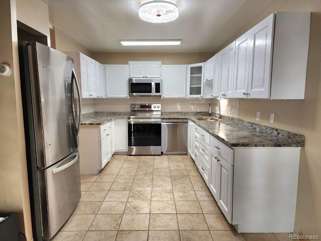 9655 Center Avenue, Unit 5A Denver, CO 80247 - Photo 5 of 45 a large kitchen with stainless steel appliances granite countertop a refrigerator sink and cabinets