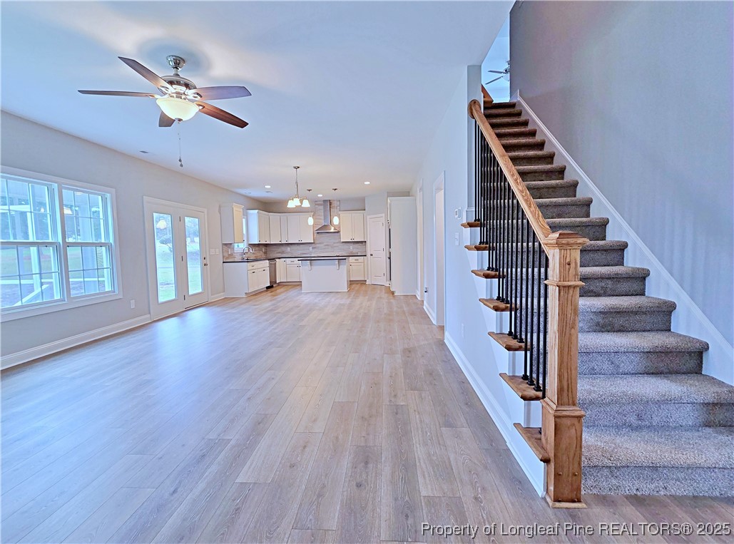 425 Shawcroft Road Fayetteville, NC 28311 - Photo 9 of 50 a view of an empty room with wooden floor stairs and a ceiling fan
