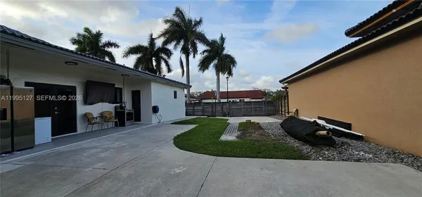 a view of a house with backyard and sitting area