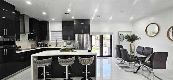 a kitchen with a table chairs sink and cabinets