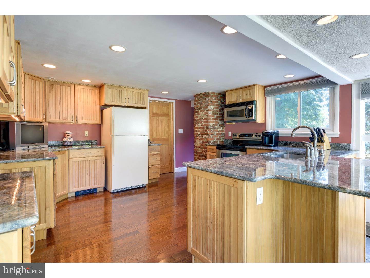 500 Gulph Road Wayne, PA 19087 - Photo 7 of 25 a kitchen with stainless steel appliances granite countertop a refrigerator a oven a sink a dining table and chairs with wooden floor