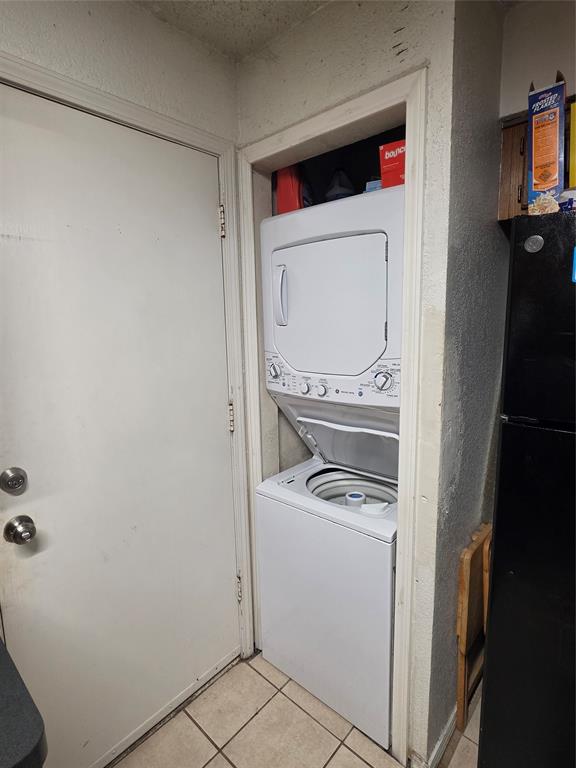 13219 Emily Road, Unit 4104 Dallas, TX 75240 - Photo 3 of 7 The property includes a stacked washer and dryer unit, conveniently located in a dedicated alcove, complemented by tiled flooring