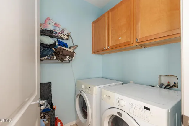 a utility room with dryer washer and a fridge