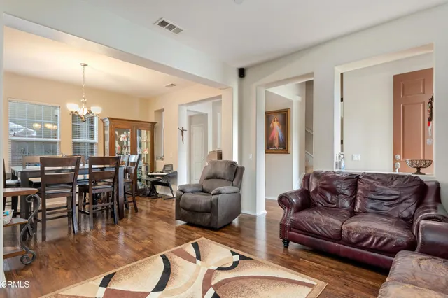 a living room with furniture kitchen view and a large window
