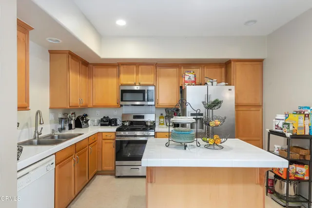 a kitchen with stainless steel appliances a stove a sink dishwasher and a refrigerator