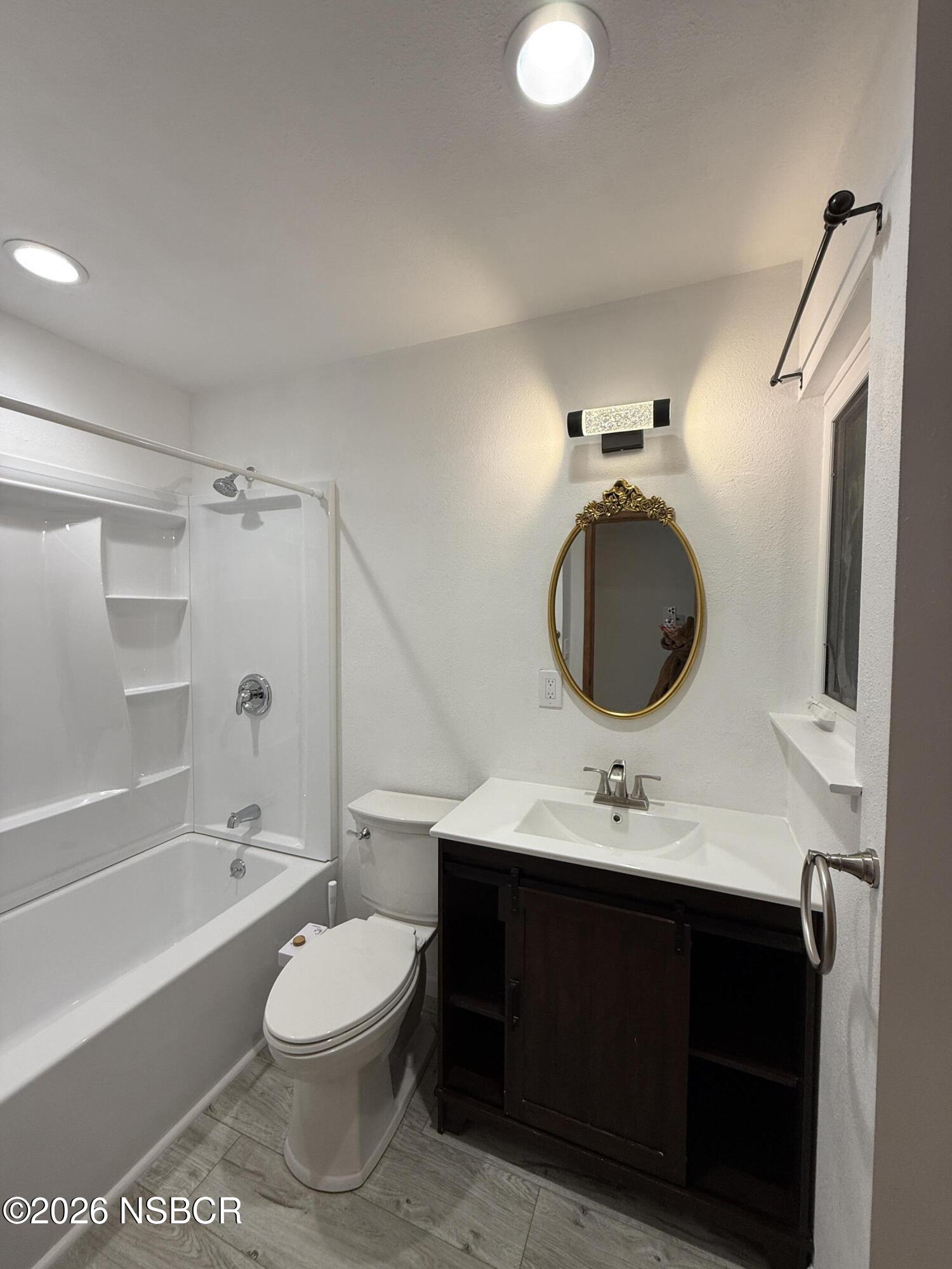 1408 West Walnut Avenue Lompoc, CA 93436 - Photo 11 of 27 a bathroom with a granite countertop sink toilet a mirror and bathtub