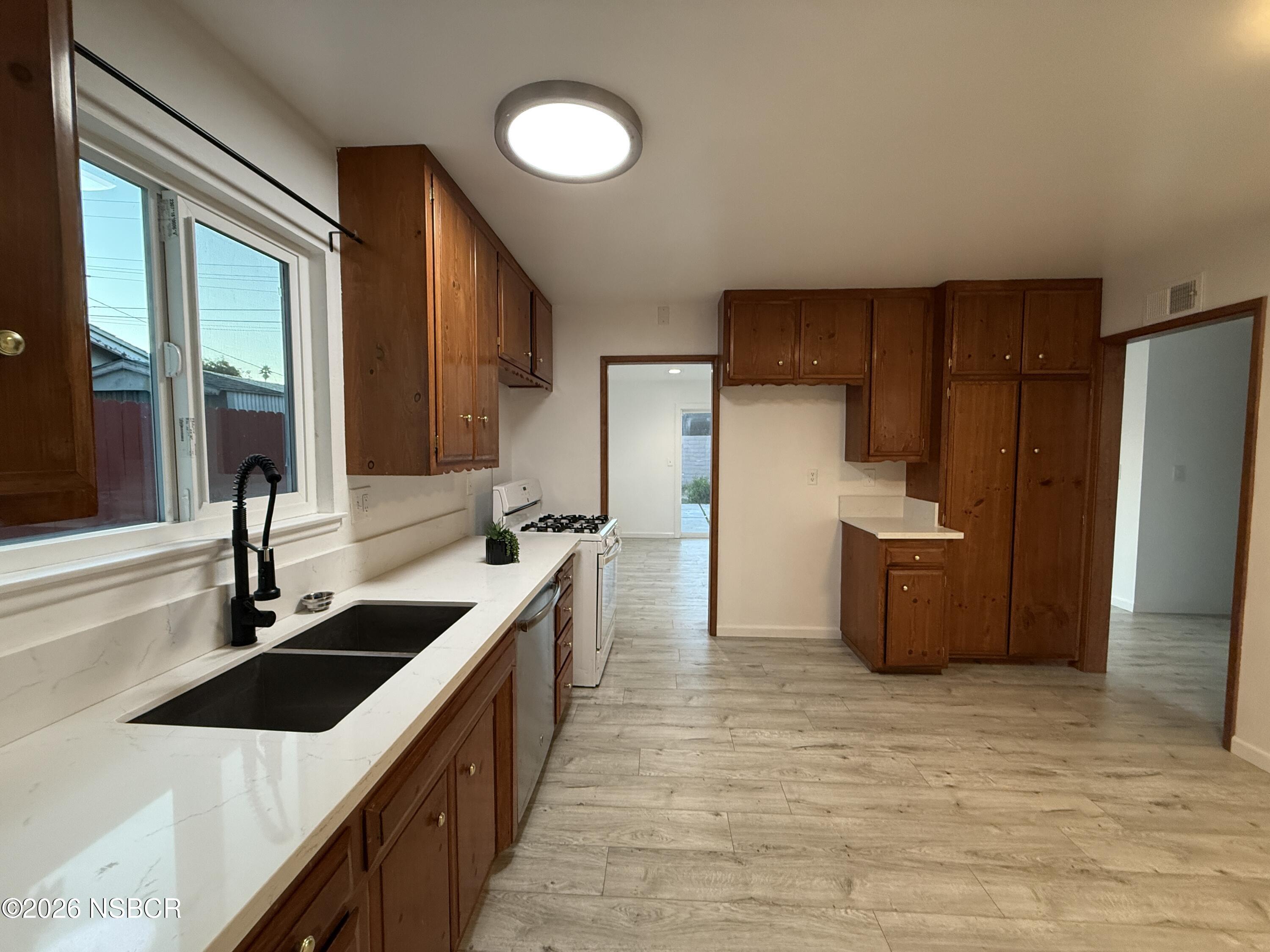 1408 West Walnut Avenue Lompoc, CA 93436 - Photo 5 of 27 a kitchen with stainless steel appliances granite countertop a sink stove and refrigerator