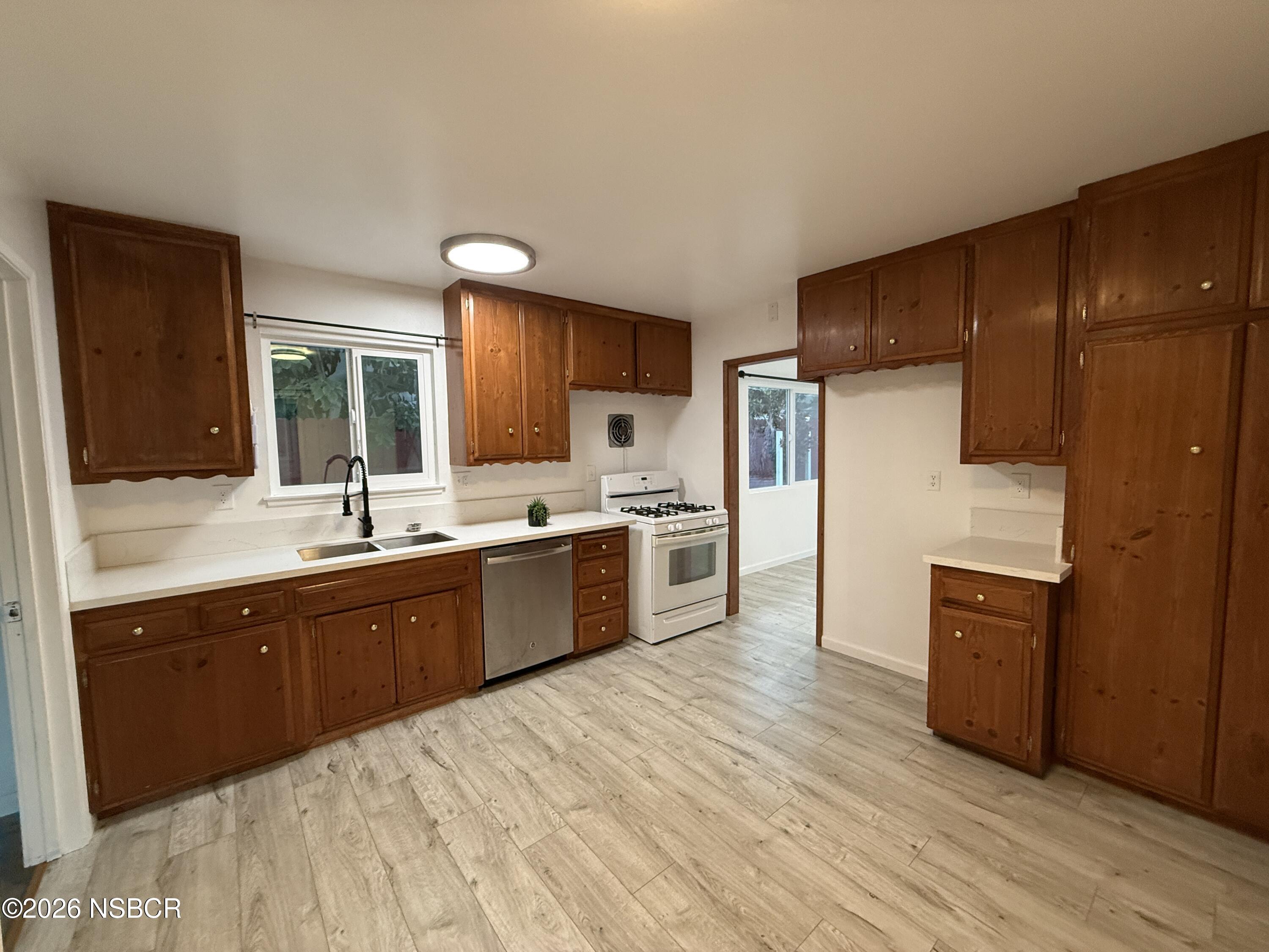 1408 West Walnut Avenue Lompoc, CA 93436 - Photo 6 of 27 a large kitchen with a sink stainless steel appliances and cabinets