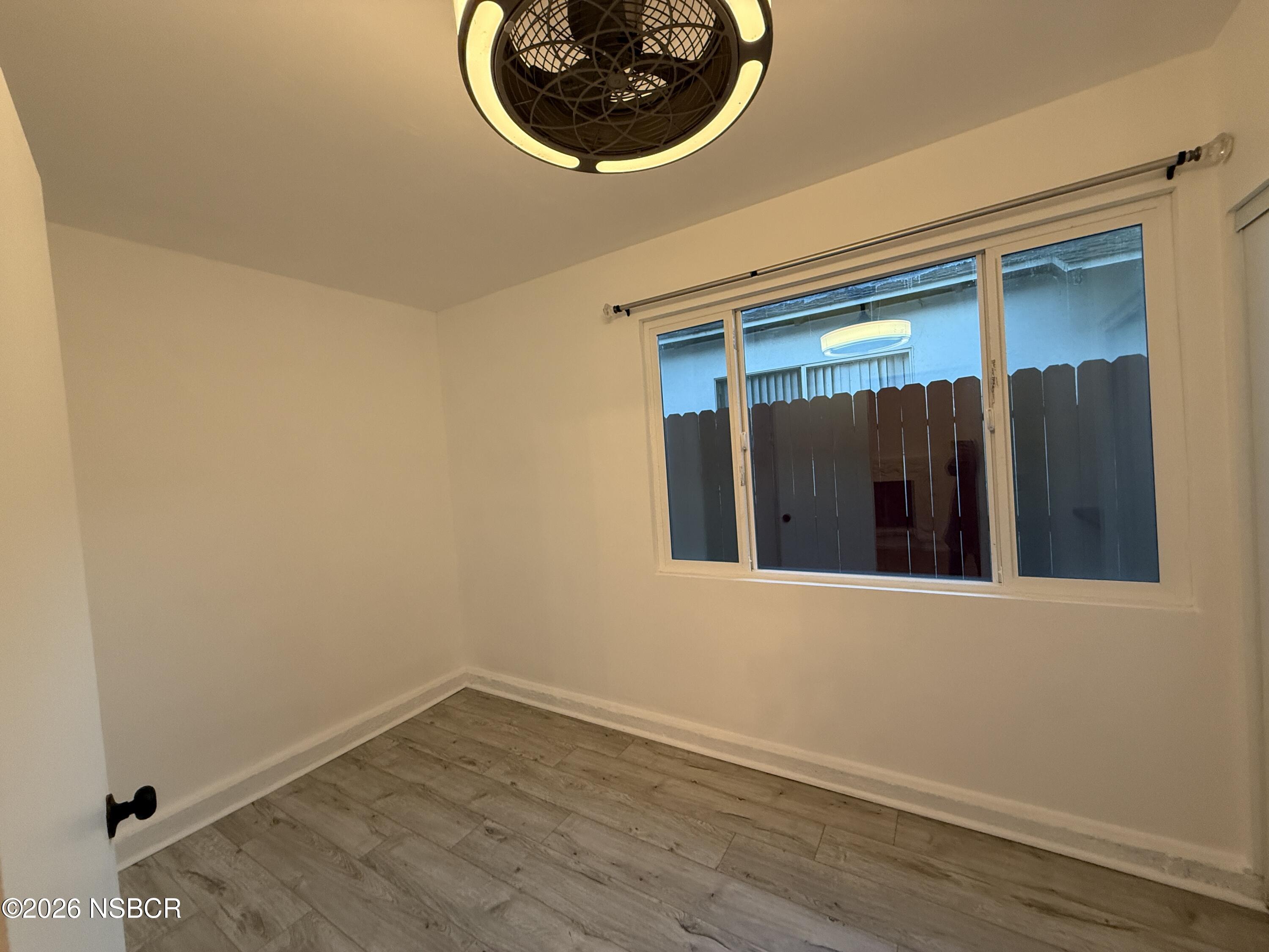 1408 West Walnut Avenue Lompoc, CA 93436 - Photo 9 of 27 a view of a small space with wooden floor and a window