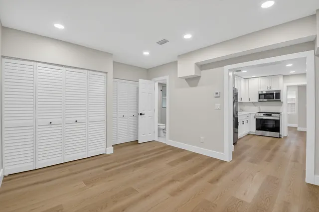 wooden floor in an empty room with a kitchen