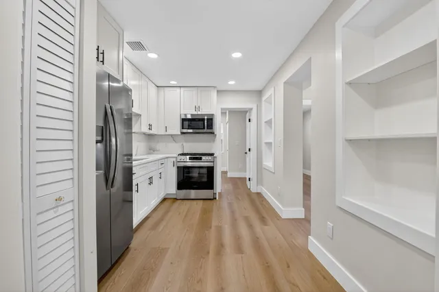 a kitchen with white cabinets and stainless steel appliances