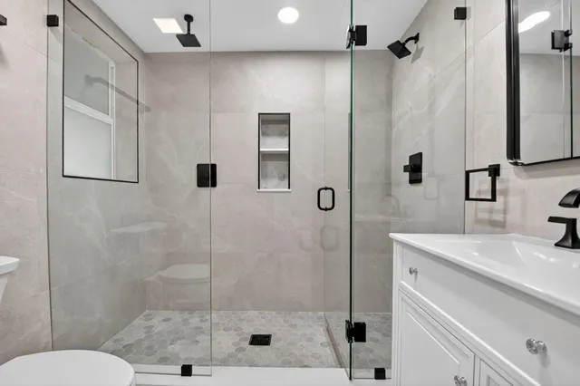 a bathroom with a sink a toilet and shower