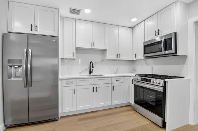 a kitchen with cabinets stainless steel appliances and a counter space