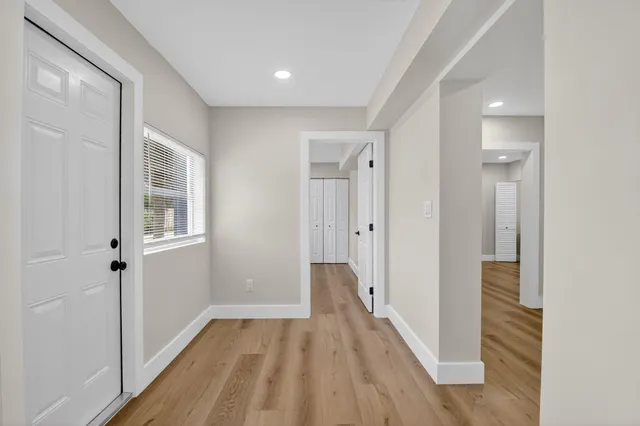 a view of a hallway with wooden floor and closet area