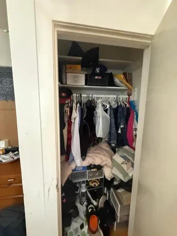 a view of walk in closet with clothes and shoes