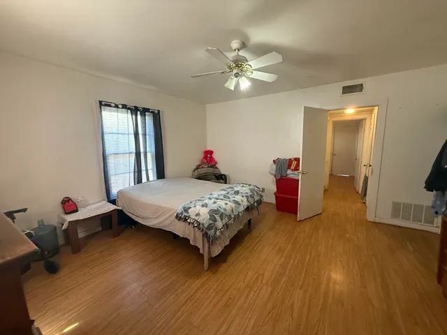 a bedroom with a bed and wooden floor