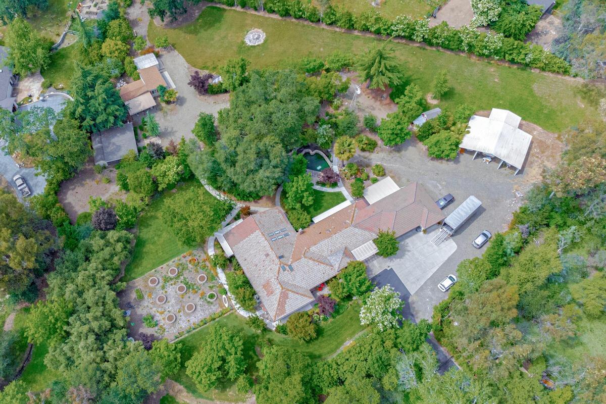 an aerial view of a house with a garden and lake view