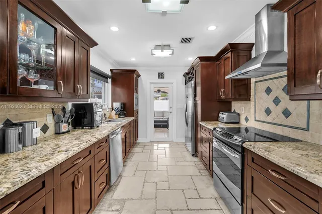 a large kitchen with stainless steel appliances granite countertop a stove and a sink