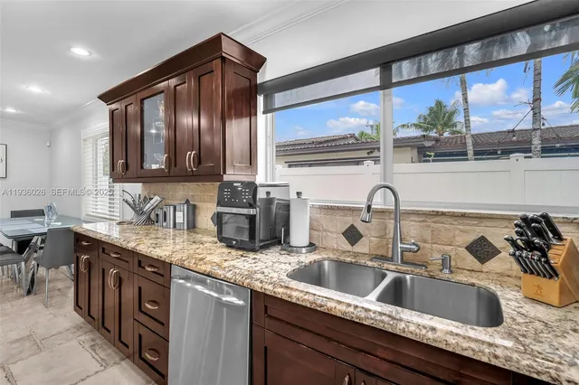 a kitchen with stainless steel appliances granite countertop a sink and a wooden cabinets