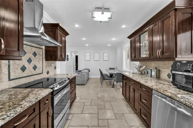 a kitchen with stainless steel appliances granite countertop a sink stove and refrigerator