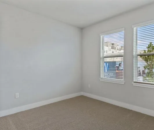 a view of a big room with wooden floor and windows