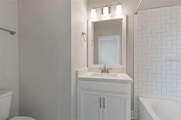 a bathroom with a granite countertop toilet and a shower