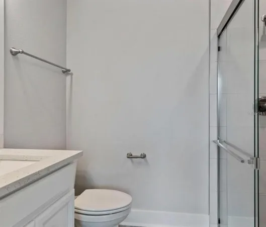 a bathroom with a granite countertop toilet a sink and shower