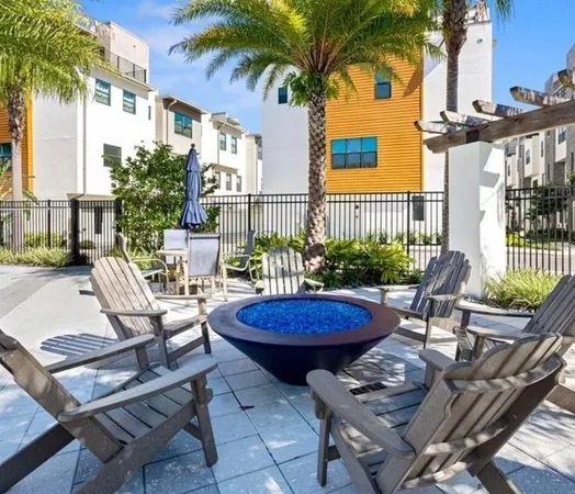a view of a patio with table and chairs potted plants and palm tree