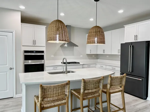 a kitchen with stainless steel appliances a stove a refrigerator a sink and a stove