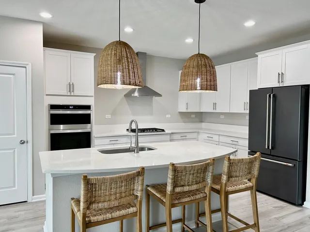 a kitchen with stainless steel appliances a stove a refrigerator a sink and a stove