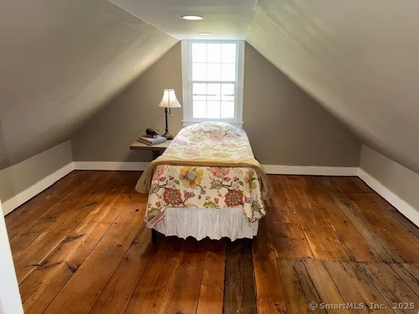 a bed sitting in a bedroom next to a window