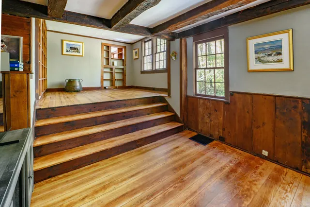 a view of a bedroom with wooden floor and a window