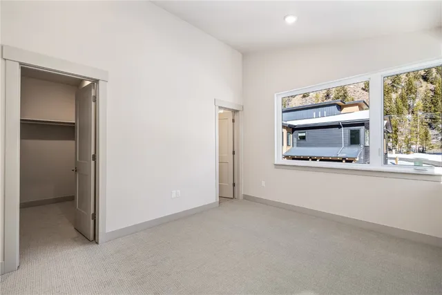 an empty room with windows and fireplace
