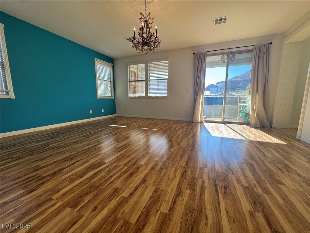 5553 Fairmeade Way Las Vegas, NV 89135 - Photo 17 of 42 Empty room featuring dark wood-style floors and a chandelier
