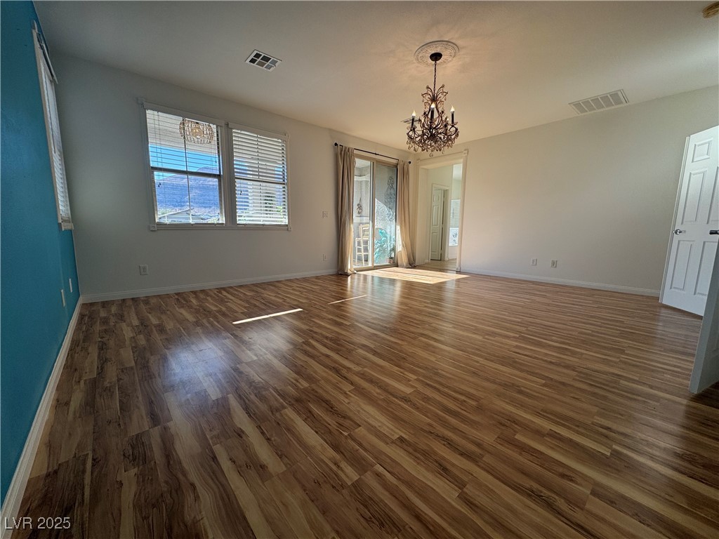 5553 Fairmeade Way Las Vegas, NV 89135 - Photo 18 of 42 Spare room featuring dark wood finished floors and a chandelier