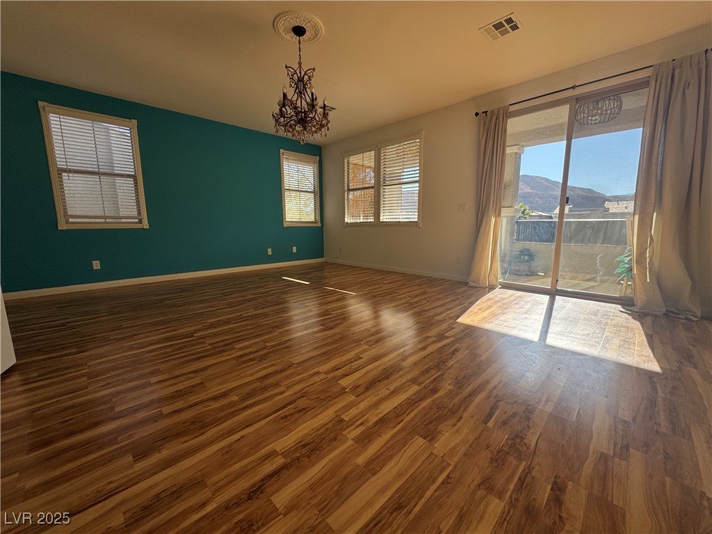 5553 Fairmeade Way Las Vegas, NV 89135 - Photo 19 of 42 Unfurnished room featuring dark wood-style floors, a mountain view, and a chandelier