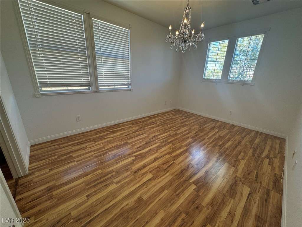 5553 Fairmeade Way Las Vegas, NV 89135 - Photo 26 of 42 Unfurnished room with wood finished floors and a chandelier