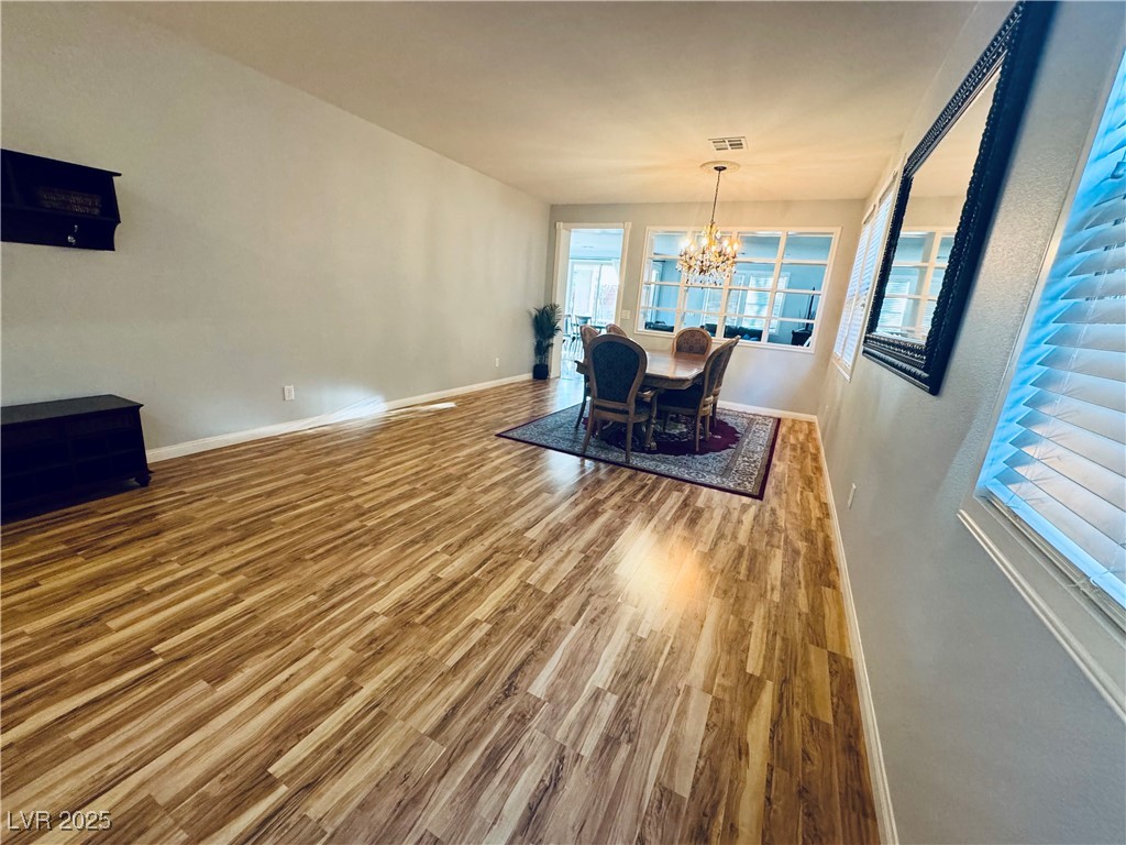 5553 Fairmeade Way Las Vegas, NV 89135 - Photo 4 of 42 Dining room featuring a chandelier and wood finished floors