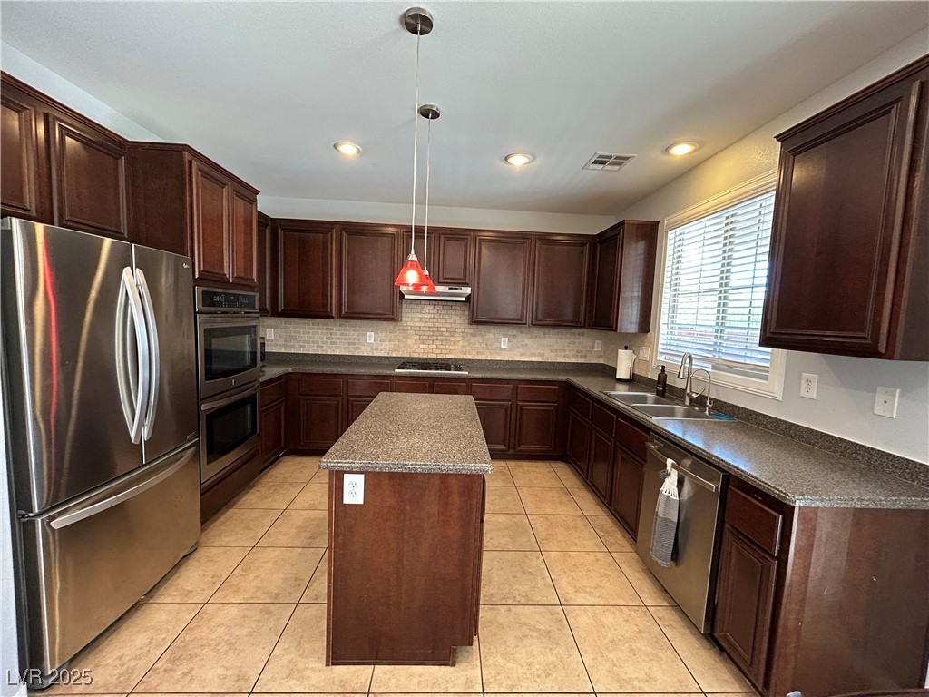 5553 Fairmeade Way Las Vegas, NV 89135 - Photo 8 of 42 Kitchen with dark brown cabinets, stainless steel appliances, dark countertops, decorative light fixtures, and recessed lighting