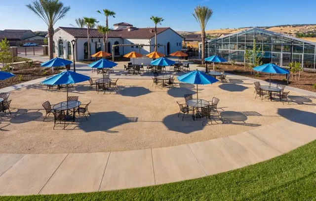 a view of a tennis ground with furniture and lake view