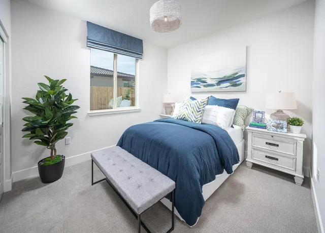 a bedroom with a bed and a potted plant