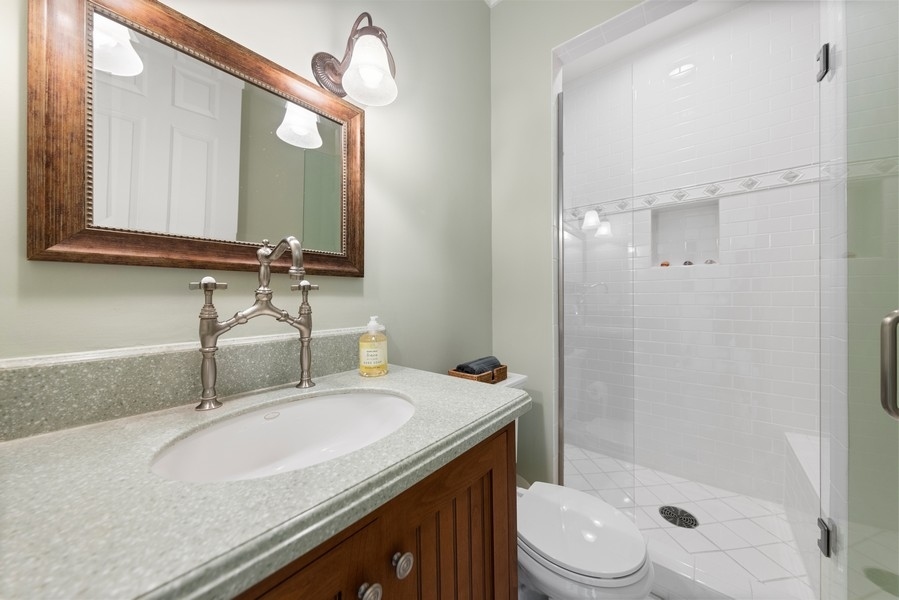 711 South County Line Road Hinsdale, IL 60521 - Photo 15 of 42 a bathroom with a granite countertop sink toilet and shower
