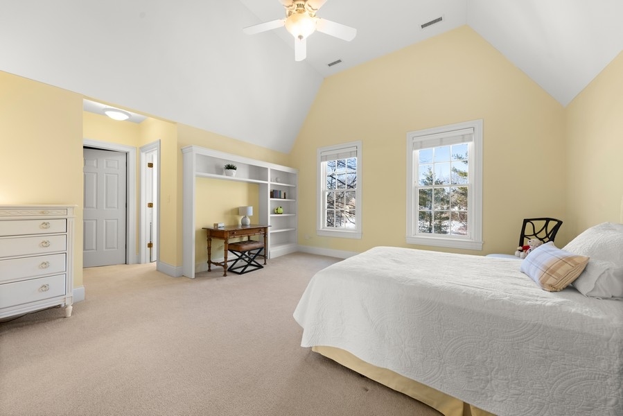 711 South County Line Road Hinsdale, IL 60521 - Photo 23 of 42 a spacious bedroom with a bed a dresser and a chandelier
