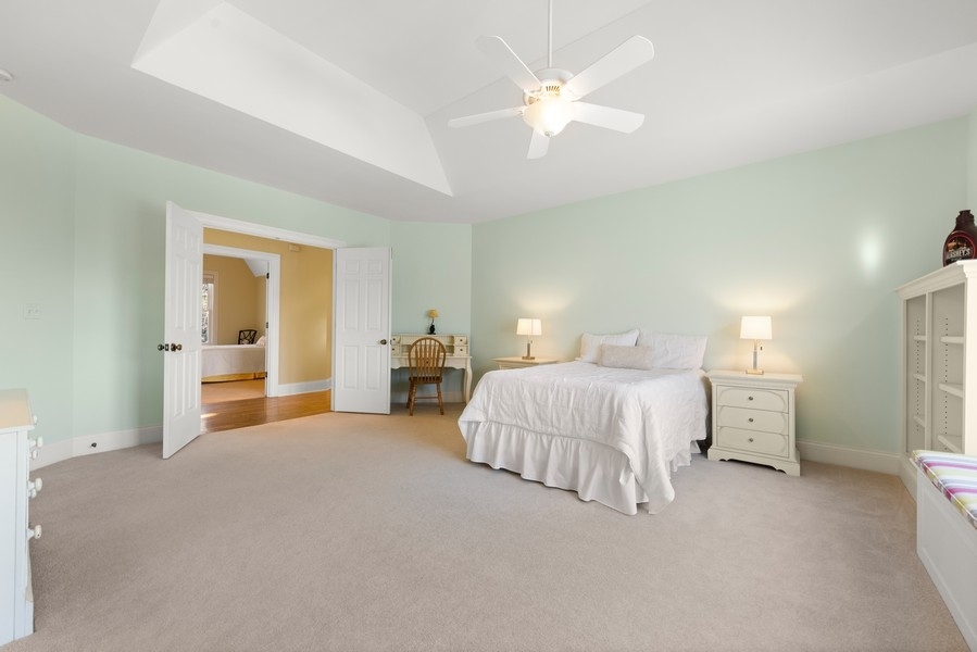 711 South County Line Road Hinsdale, IL 60521 - Photo 25 of 42 a spacious bedroom with a bed and a chandelier