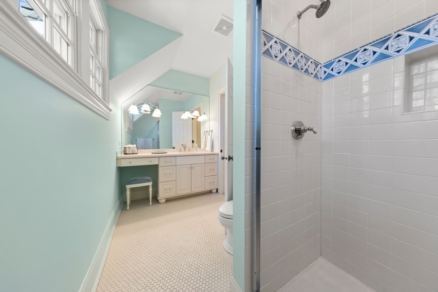 711 South County Line Road Hinsdale, IL 60521 - Photo 27 of 42 a bathroom with a sink a mirror and a shower